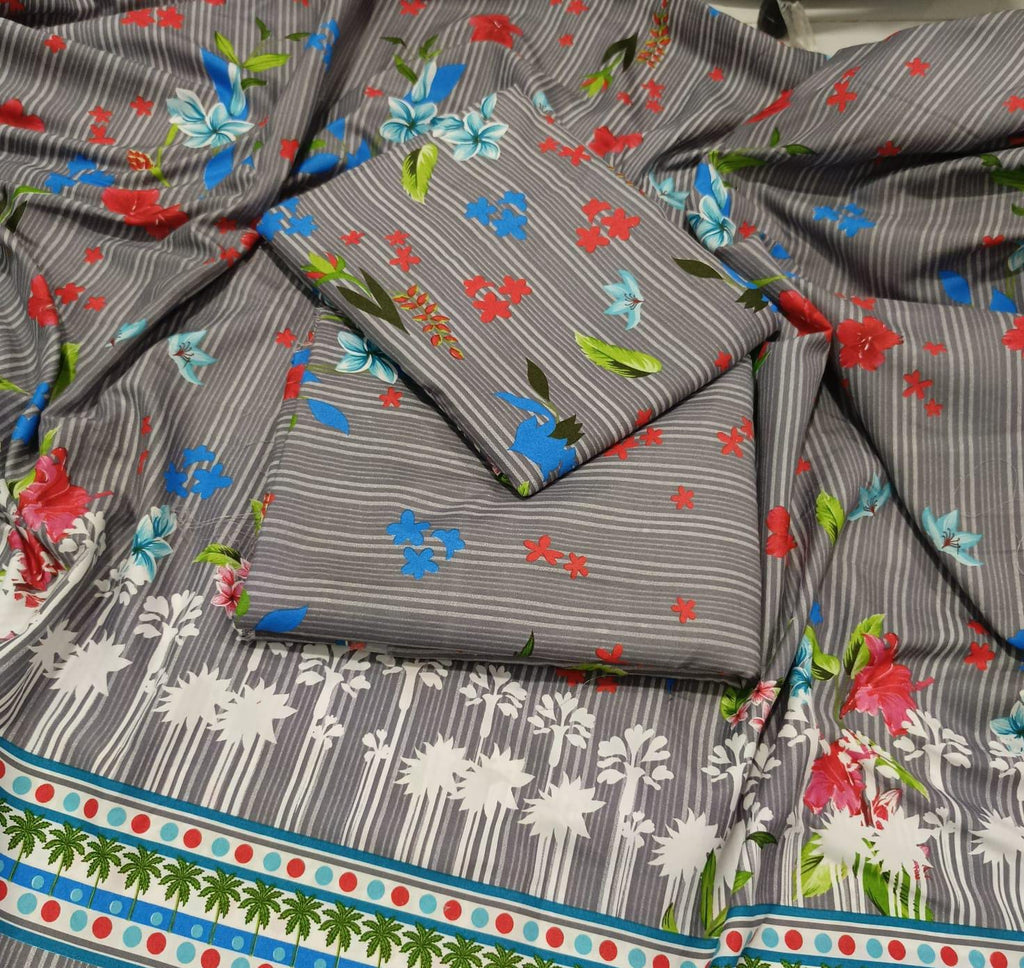 A folded and draped piece of gray fabric with a multicolor floral and striped print, featuring white palm tree motifs and a decorative border with red, blue, green, and white details.