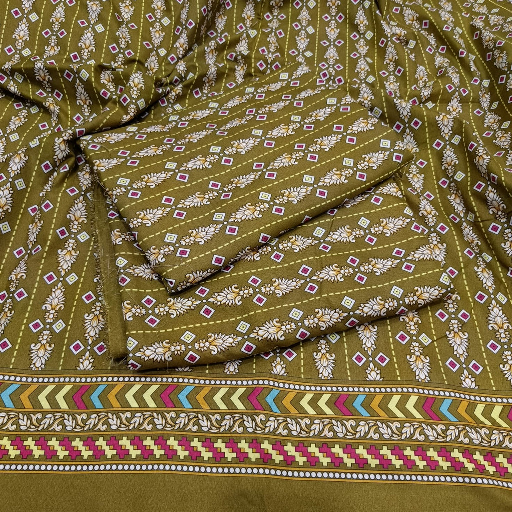 An olive green fabric with a detailed block print pattern of white flowers, small pink and green diamonds, and a colorful geometric border at the bottom.